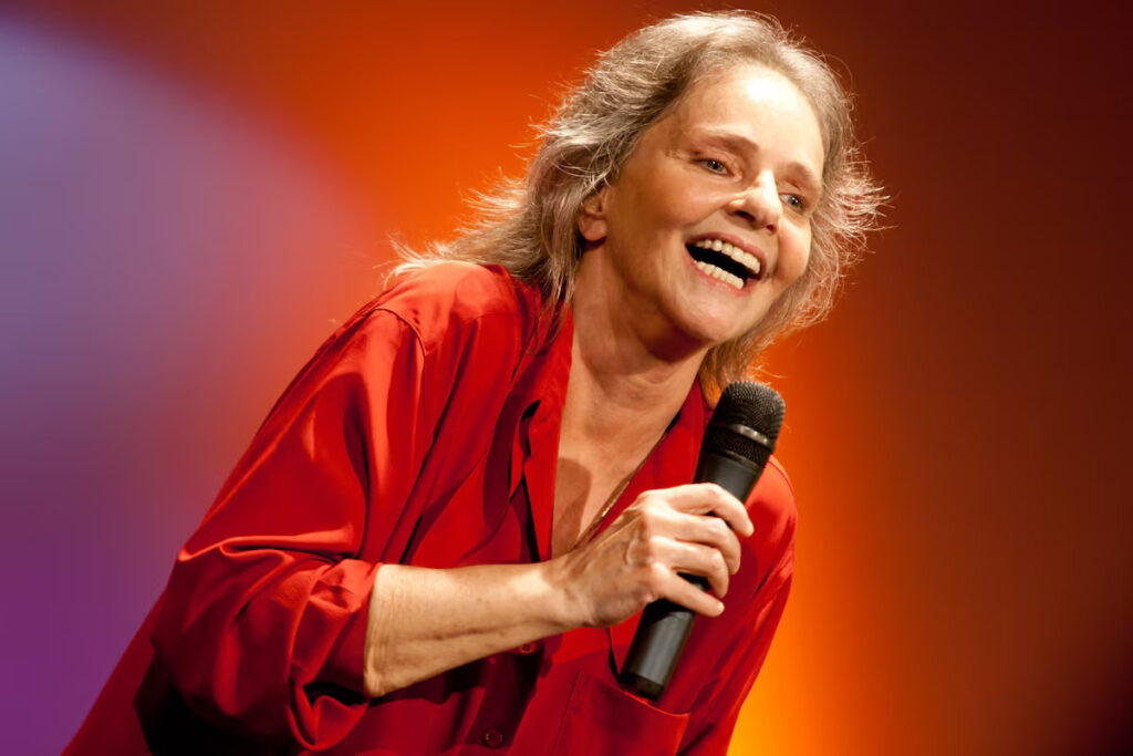 Angela Ro Ro segurando microfone durante apresentação musical