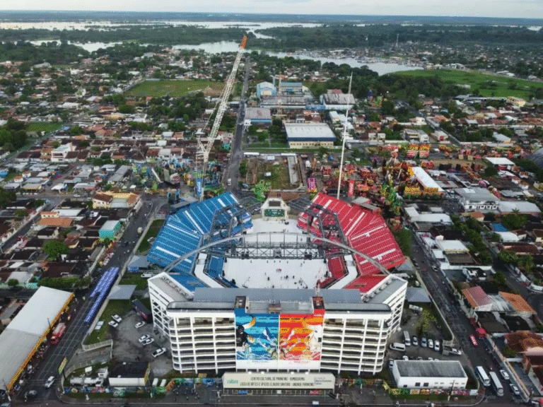 Imagem aérea mostra o Bumbódromo de Parintins com as arquibancadas azul e vermelha, símbolo do Festival Folclórico que reúne Caprichoso e Garantido no Amazonas.