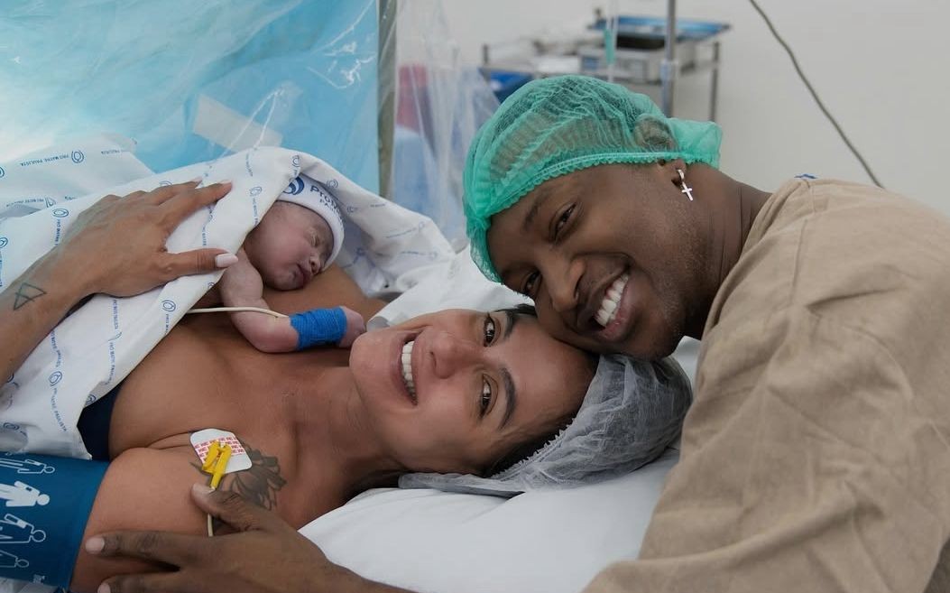 Thiaguinho e Carol Peixinho posam sorridentes ao lado do filho recém-nascido, Bento, em maternidade de São Paulo
