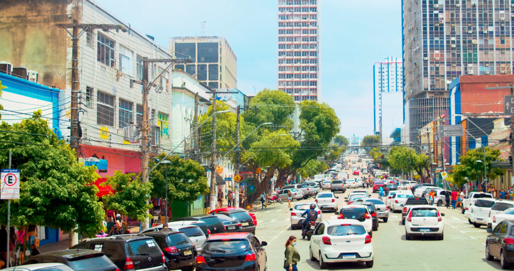 Rua movimentada de Manaus com carros, pedestres e prédios no Centro da cidade