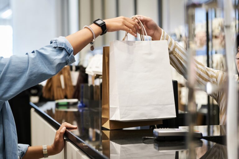 Cliente recebe sacola de compras em loja durante funcionamento do comércio em Manaus.