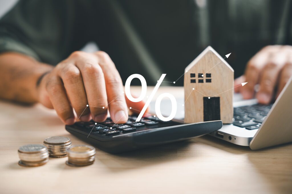 Cálculo de impostos sobre aluguel com miniatura de casa, moedas e calculadora