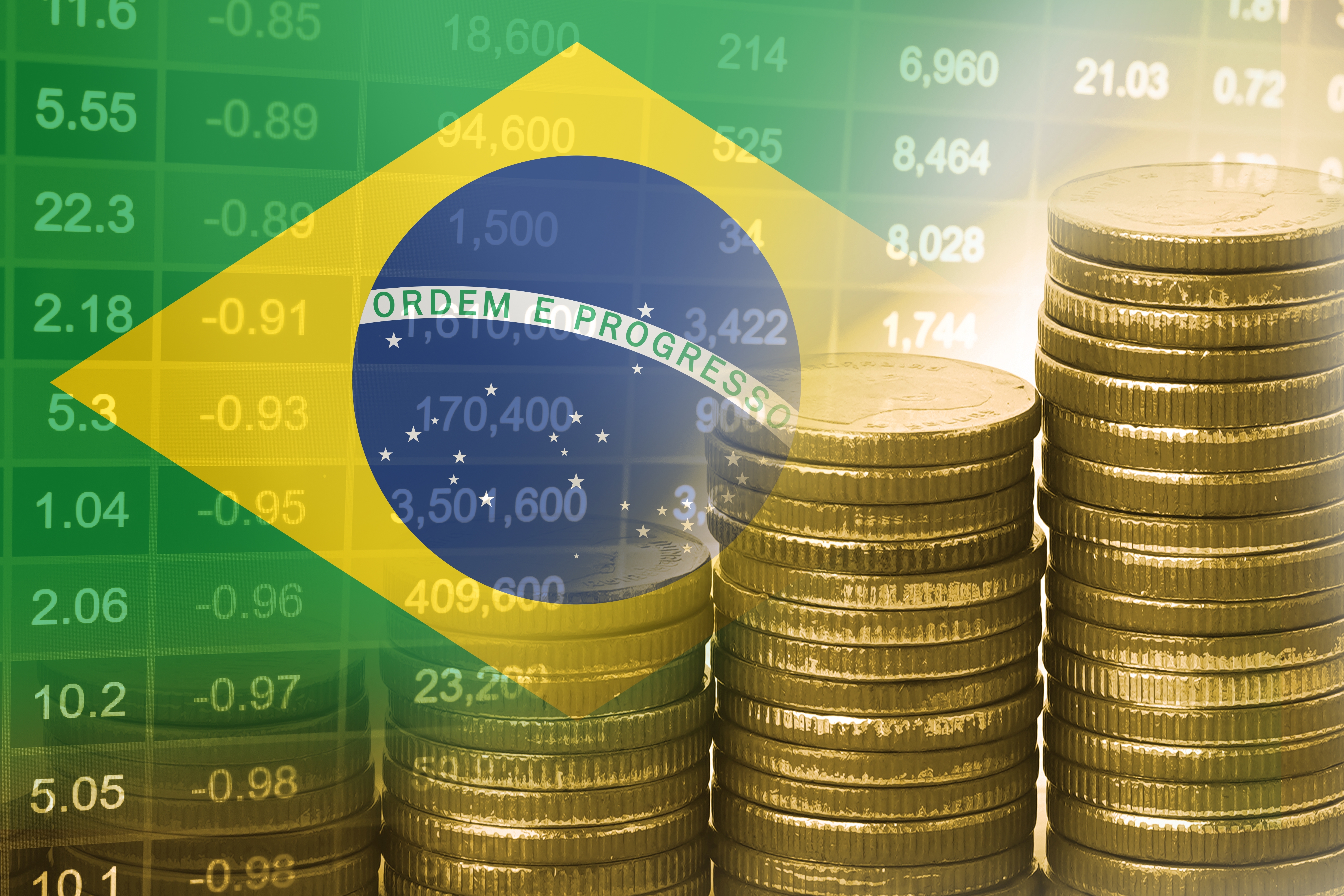 Moedas em frente à bandeira do Brasil representando o PIB brasileiro