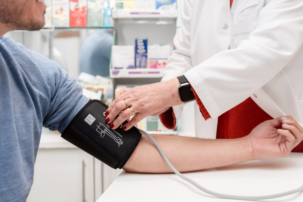 Profissional de saúde mede pressão arterial de paciente em consultório