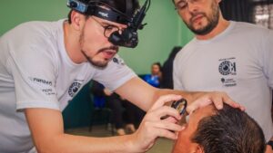 Profissional de saúde examina olho de paciente durante projeto que usa IA para detectar lesões oculares na Amazônia.