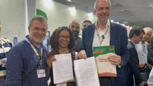 Presidente-designado da COP 30, André Corrêa do Lago, recebe documento de lideranças da floresta nos corredores do evento.