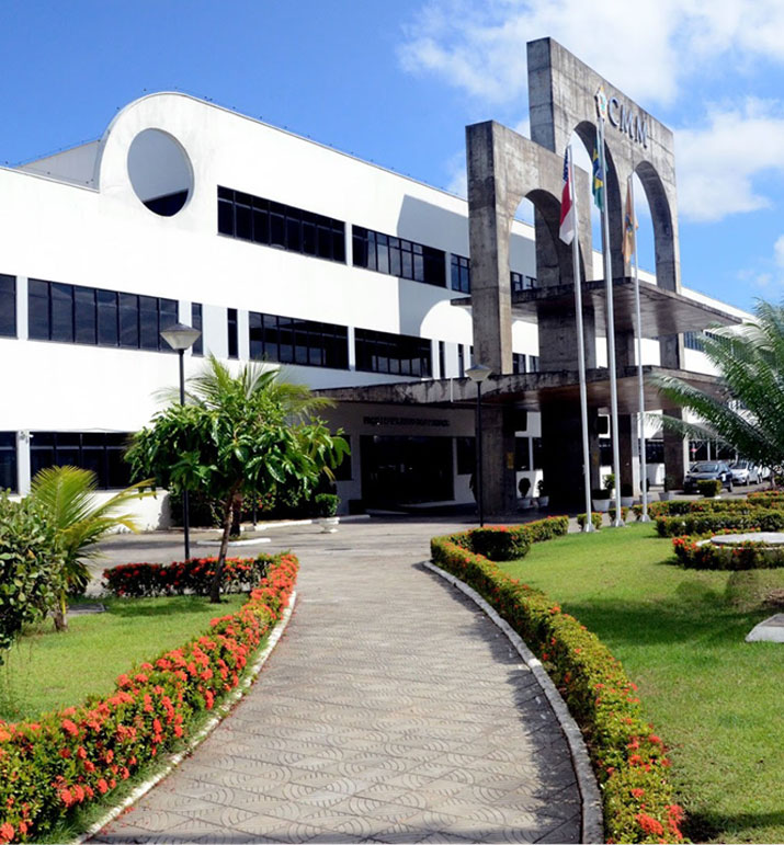 Fachada da Câmara Municipal de Manaus com jardim e bandeiras hasteadas