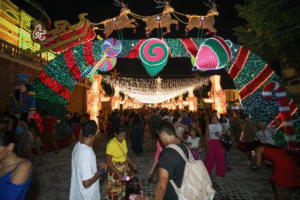 Entrada iluminada do Mundo Encantado do Natal, com arco decorado, luzes e grande público visitando a programação em Manaus.