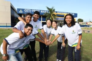 Grupo de estudantes sorrindo em frente ao CETI Profa. Maria D. Silva, representando a divulgação do calendário de matrículas 2026 no Amazonas.