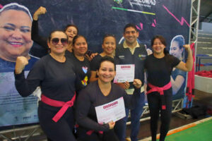 Mulheres participantes do Curso de Defesa Pessoal Feminina seguram certificados em ação realizada pela Sedel, em Manaus.