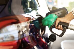 Bomba de combustível abastecendo carro com gasolina em posto após anúncio de redução de preços pela Petrobras