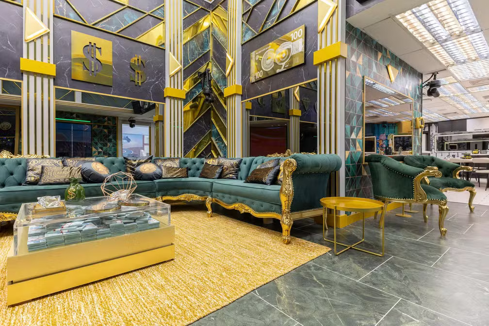 Sala da casa do BBB 26 com decoração em tons de verde e dourado