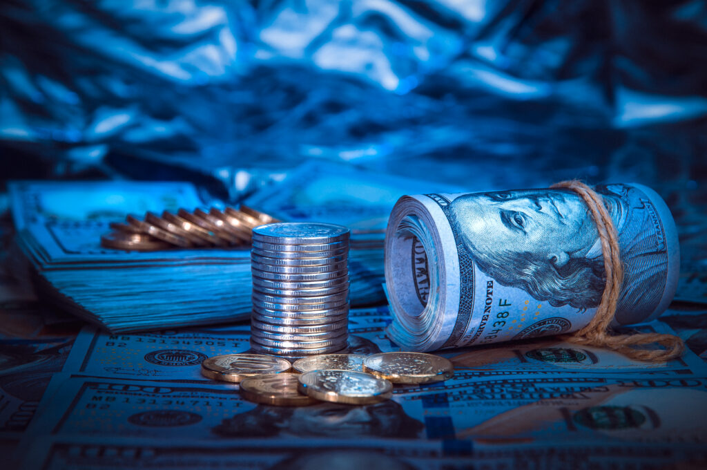 Imagem ilustrativa com notas de dólar e moedas representando grandes fortunas e ranking de bilionários da Forbes.