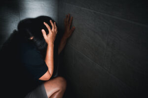 Imagem ilustrativa mostra mulher em situação de vulnerabilidade diante de violência doméstica.
