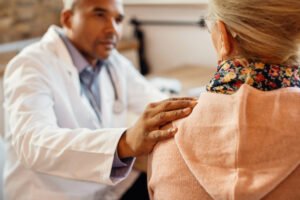 Médico conversa com paciente durante consulta; pesquisa aponta despreparo para comunicar más notícias.