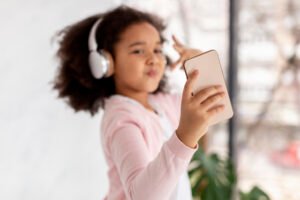 Criança usando o Spotify; Spotify libera perfis infantis para usuários gratuitos com controle parental.
