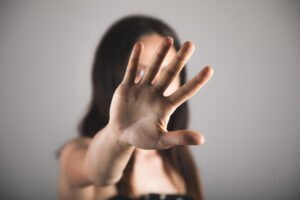 Mulher faz gesto de proteção contra violência doméstica