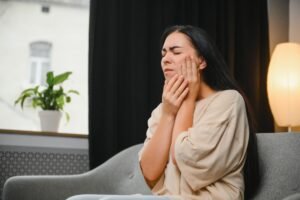 Mulher com dor na mandíbula; estudo relaciona terapia hormonal à melhora da qualidade de vida na menopausa.
