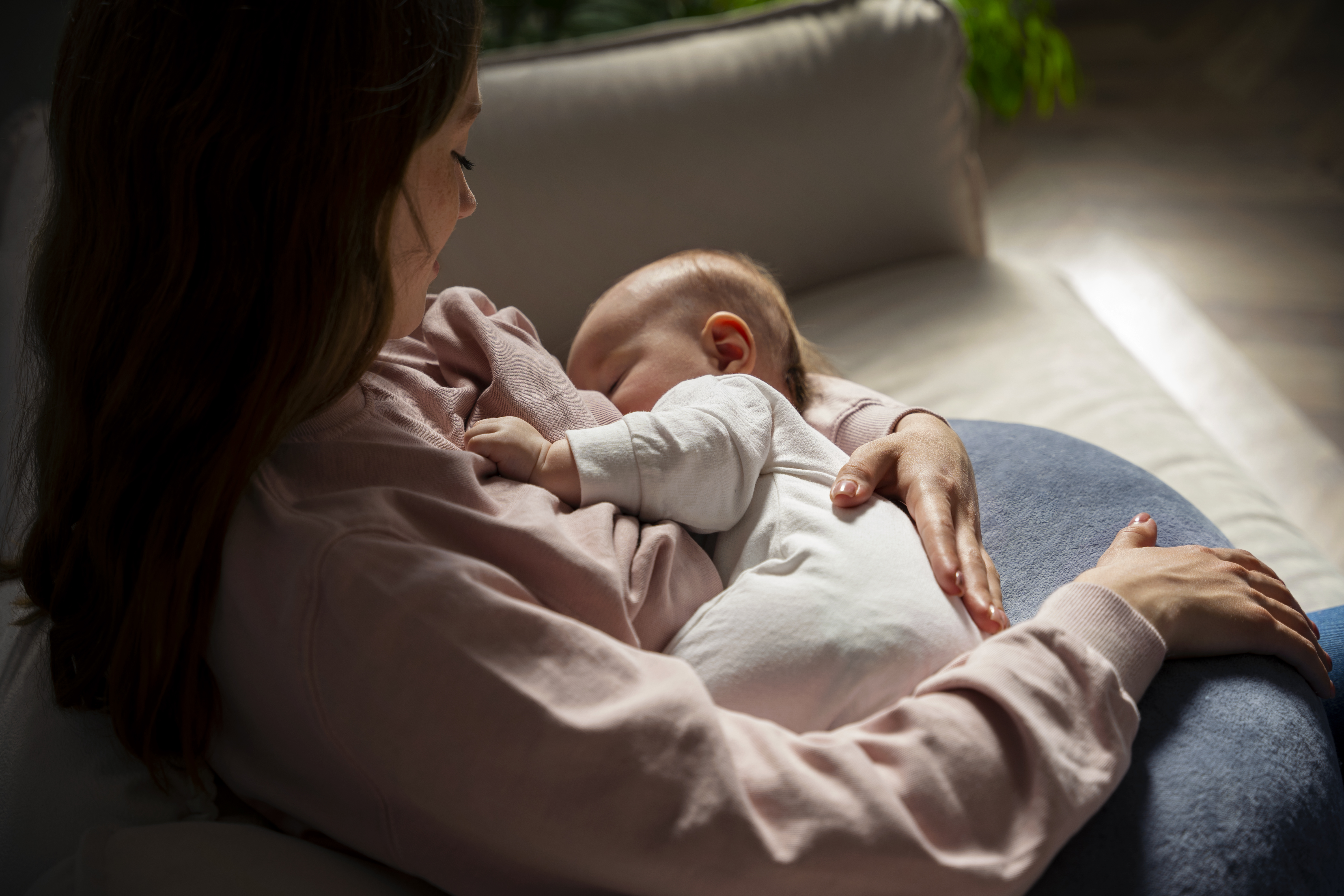 Mãe amamenta o bebê no colo; estudo mostra que a amamentação ajuda a proteger a saúde do coração das mulheres.