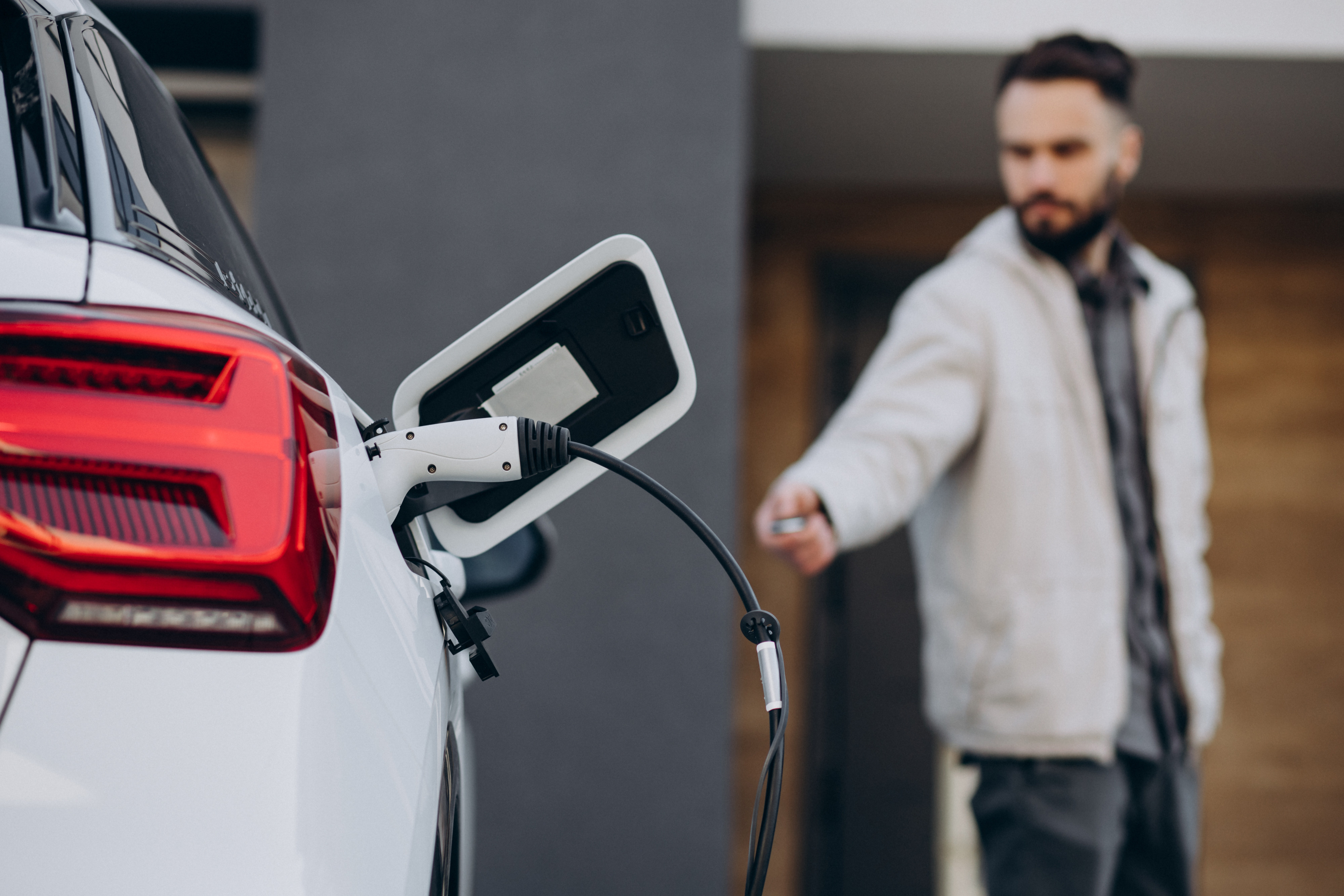 Homem conecta carro elétrico a carregador residencial; Amazonas registrou crescimento de 150% na frota de veículos elétricos em 2026.