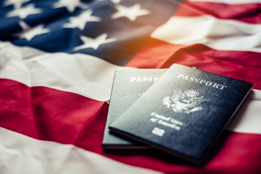 Passaportes sobre bandeira dos Estados Unidos representam processo de solicitação de visto