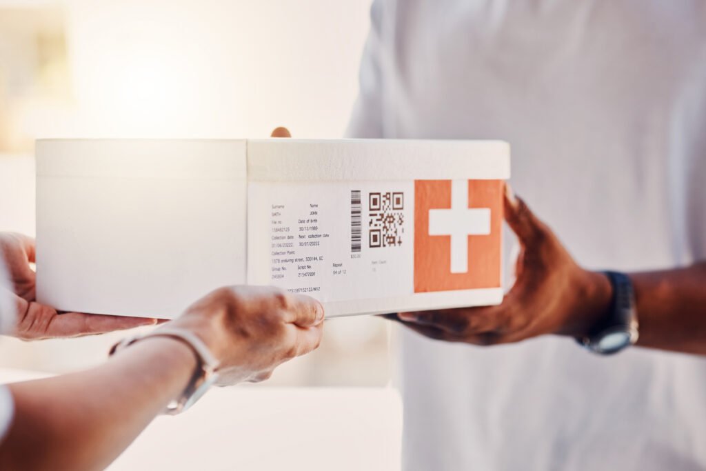 Pessoa recebe caixa de medicamentos entregue por serviço de delivery.