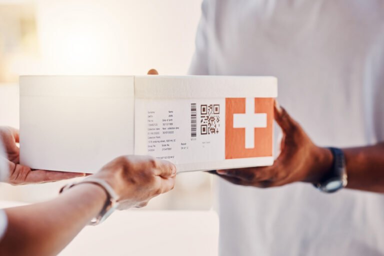 Pessoa recebe caixa de medicamentos entregue por serviço de delivery.