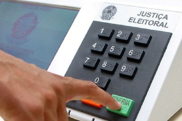 Eleitor pressiona a tecla confirma em urna eletrônica da Justiça Eleitoral