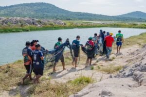 Agricultores indígenas carregam rede de pesca durante despesca de tambaqui em Boa Vista