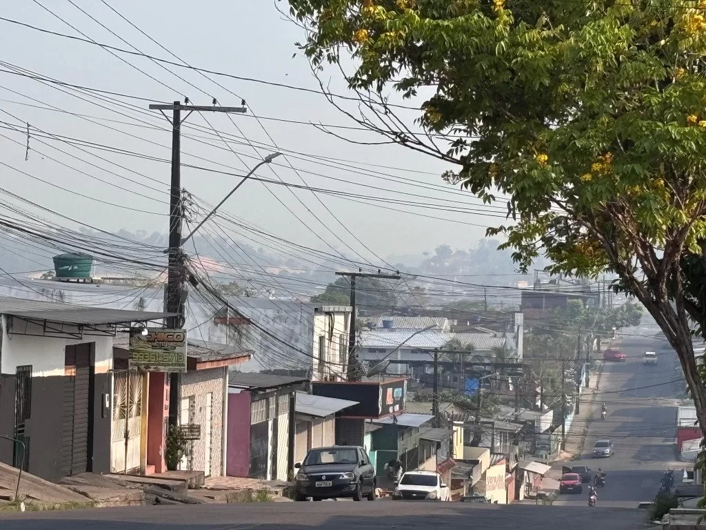 Vista de rua em Manaus encoberta por fumaça, com baixa visibilidade causada pela poluição do ar.