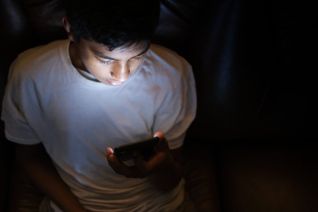 Adolescente utiliza celular em imagem ilustrativa sobre abuso sexual online