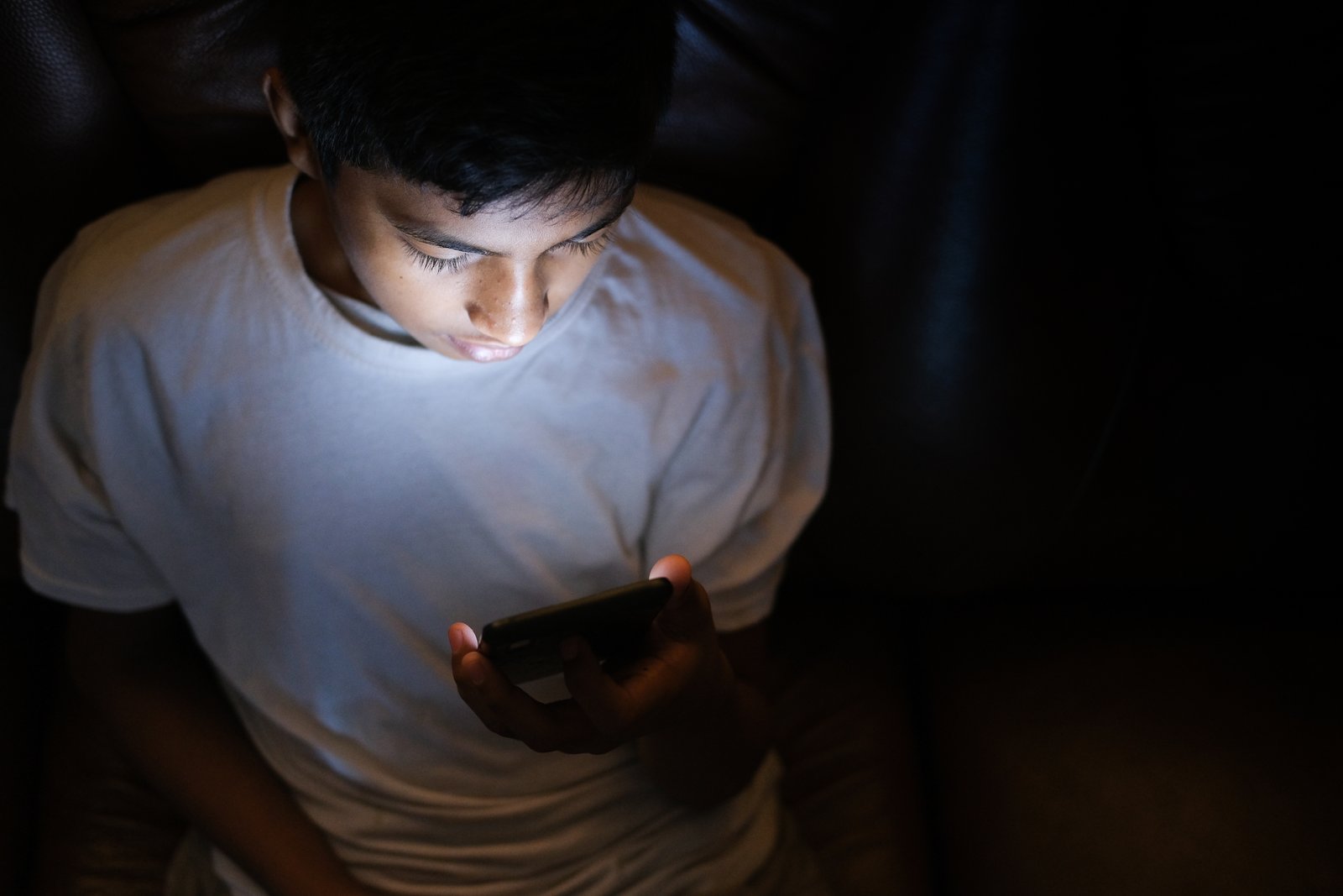 Adolescente utiliza celular em imagem ilustrativa sobre abuso sexual online