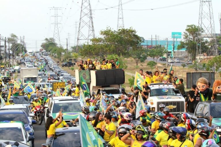Carreata com carros, motocicletas e apoiadores segurando bandeiras do Brasil durante ato de campanha em Manaus